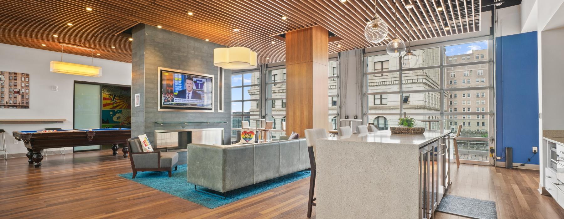 spacious lounge with wooden accents, a kitchen area and other connected amenities